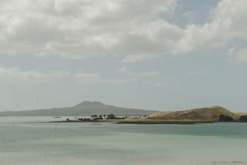 musick point landscape photography of body of water viewing mountain under white and blue sky new zealand